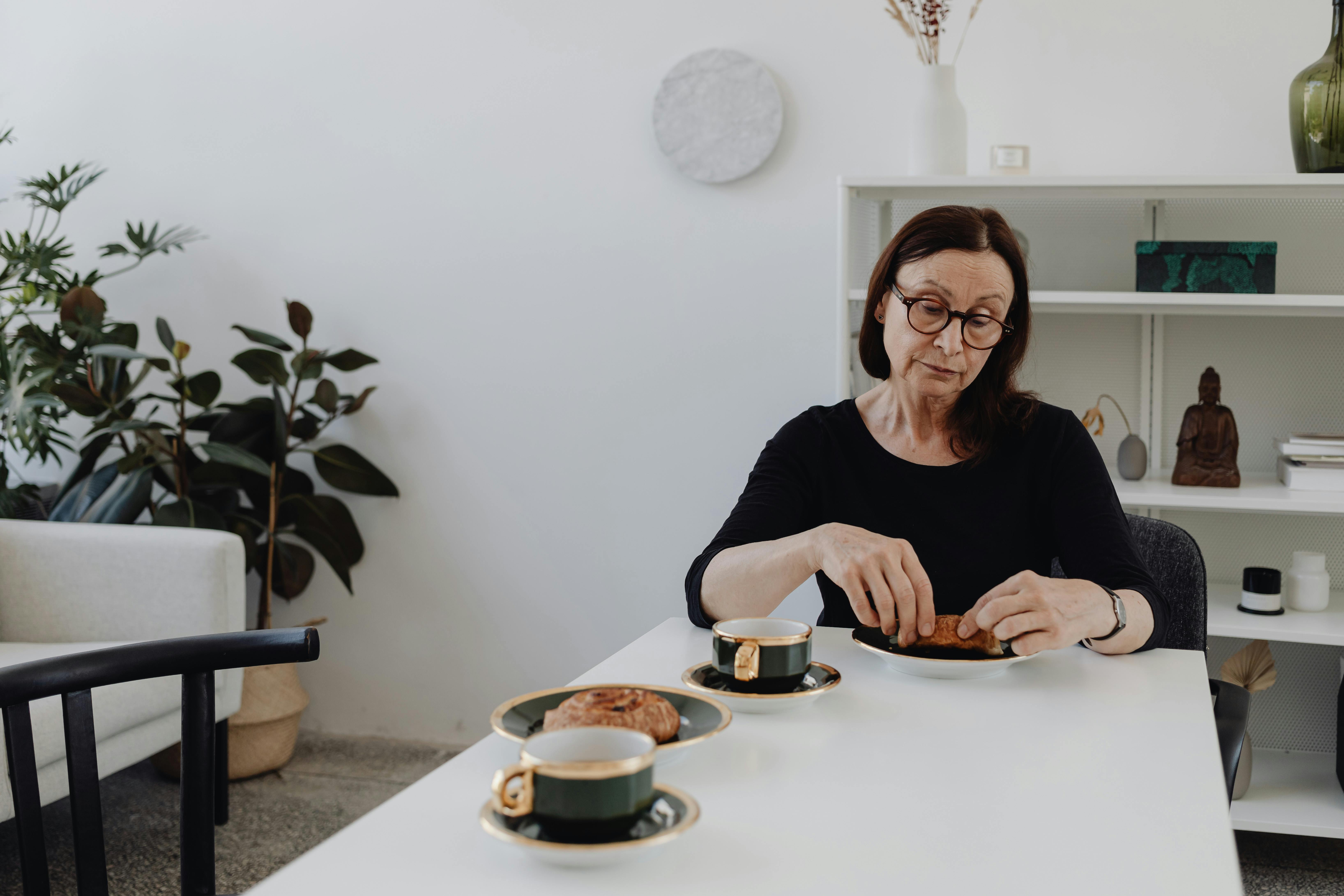 woman in black dress having breakfast alone