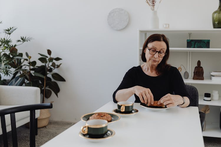 Woman In Black Dress Having Breakfast Alone