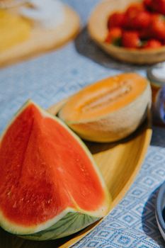 Mouthwatering watermelon and melon slices on a wooden plate, perfect for a summer treat.