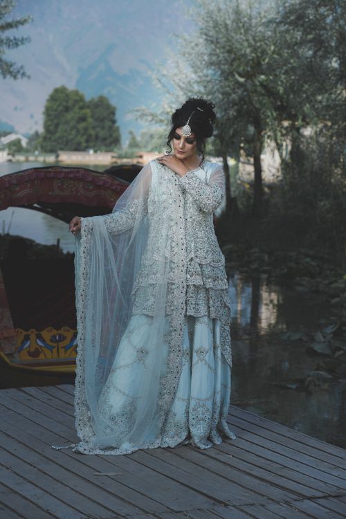 Free Beautiful South Asian bride poses elegantly by a serene lake in Srinagar. Stock Photo