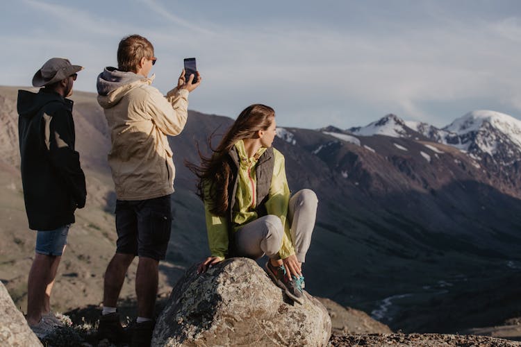 People On Top Of A Mountain Looking At View 