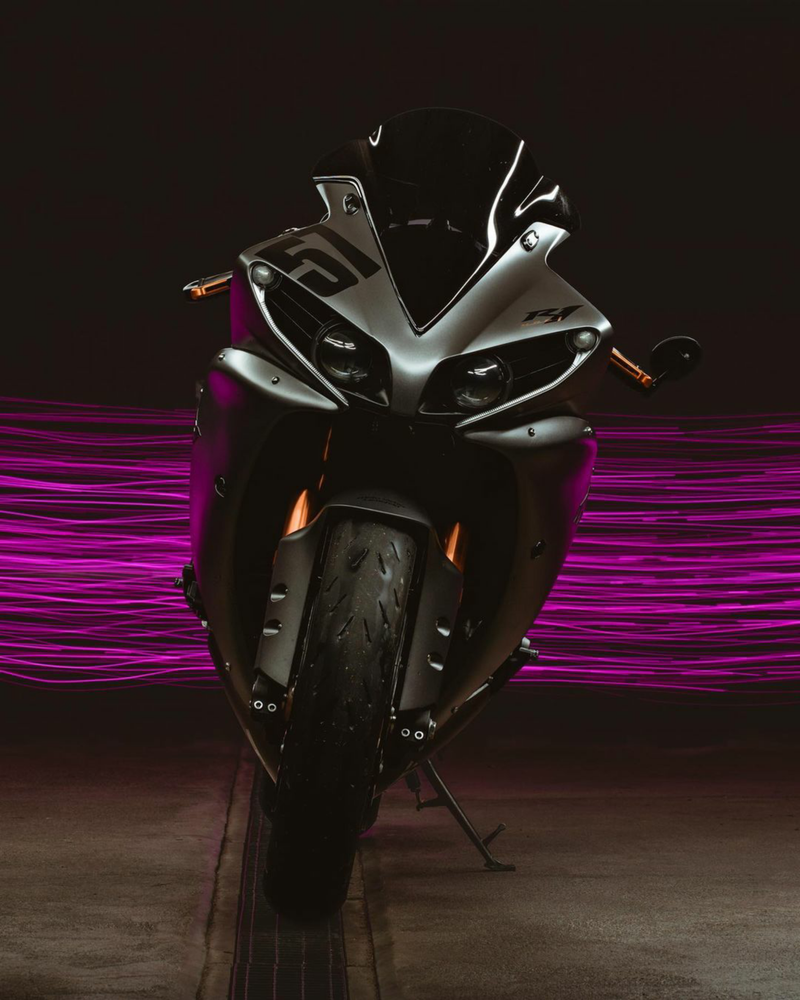 Front view of a sports motorcycle with neon purple streaks