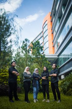 Diverse group outdoors with modern architecture, conveying unity and confidence. - Fotografer Sidoarjo