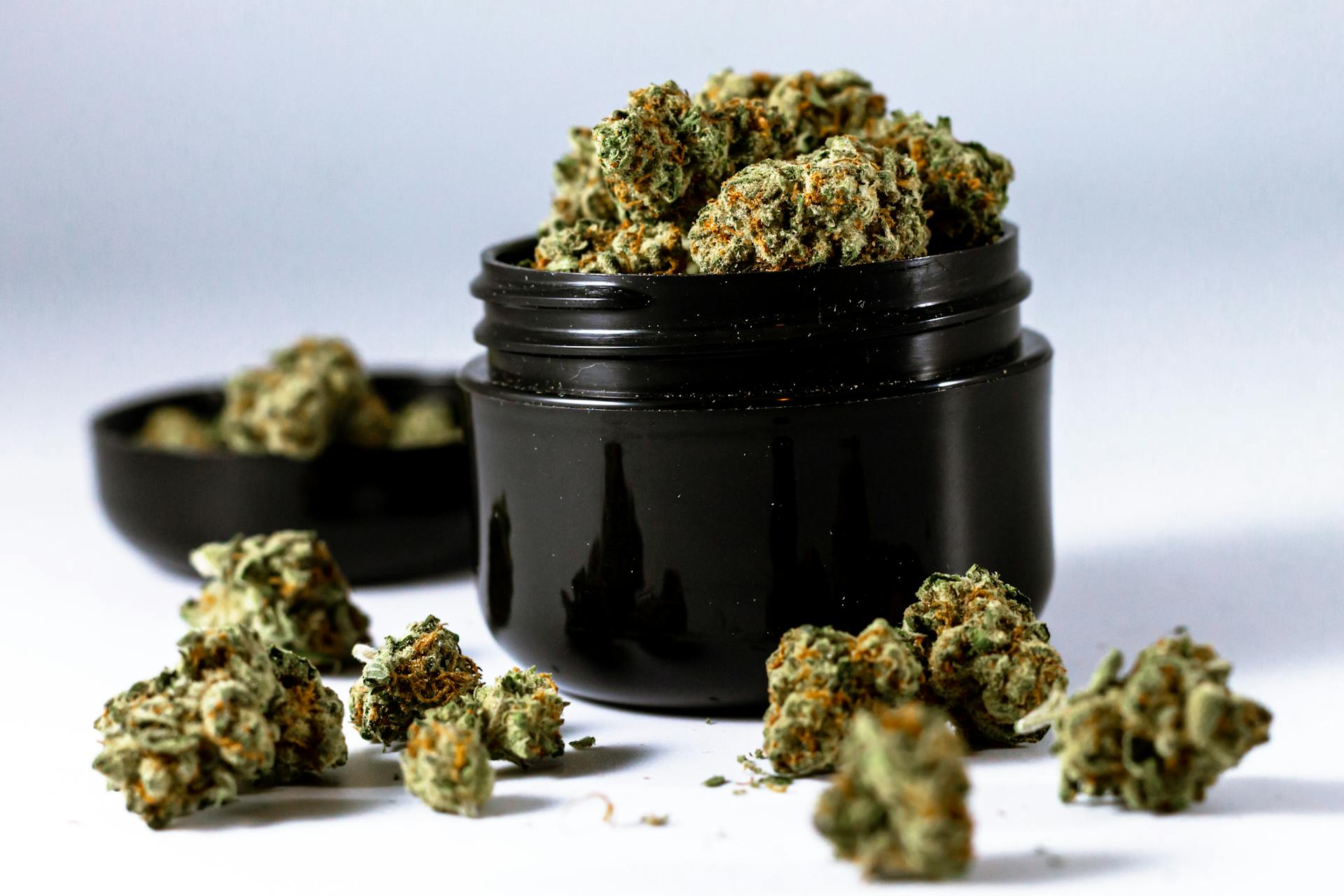 A Black Round Container Filled with Green Kush