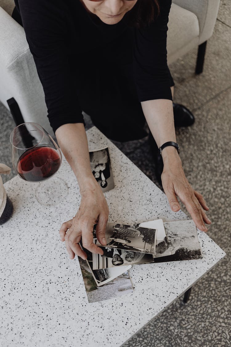 Woman With Glass Of Red Wine And Old Photographs