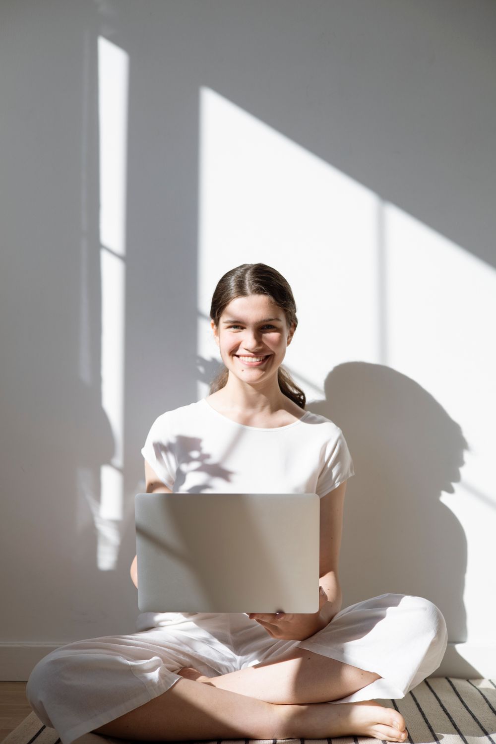 Woman Sitting on the Floor Holding a Laptop · Free Stock Photo