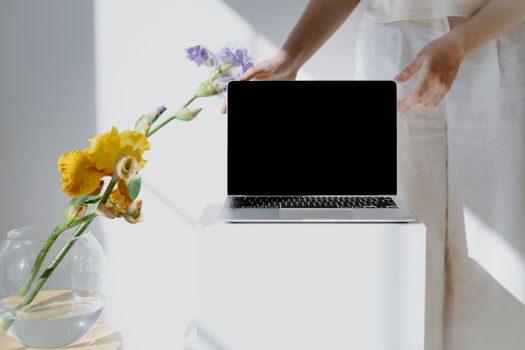 Minimalist workspace featuring a laptop and colorful flowers, perfect for creative inspiration.