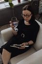 Woman in Black Shirt Sitting on Couch Holding Smartphone