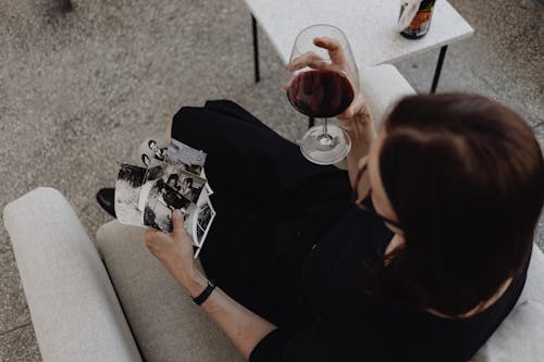 Free Top View of a Woman Holding Pictures and Wine  Stock Photo