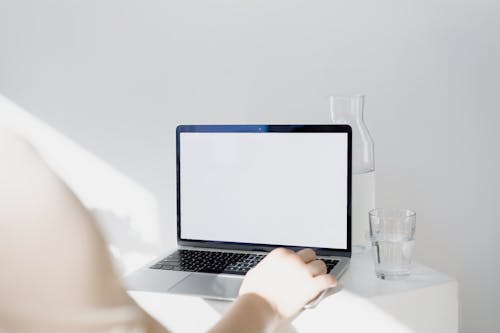 Free Person Using Macbook Pro on Table Stock Photo