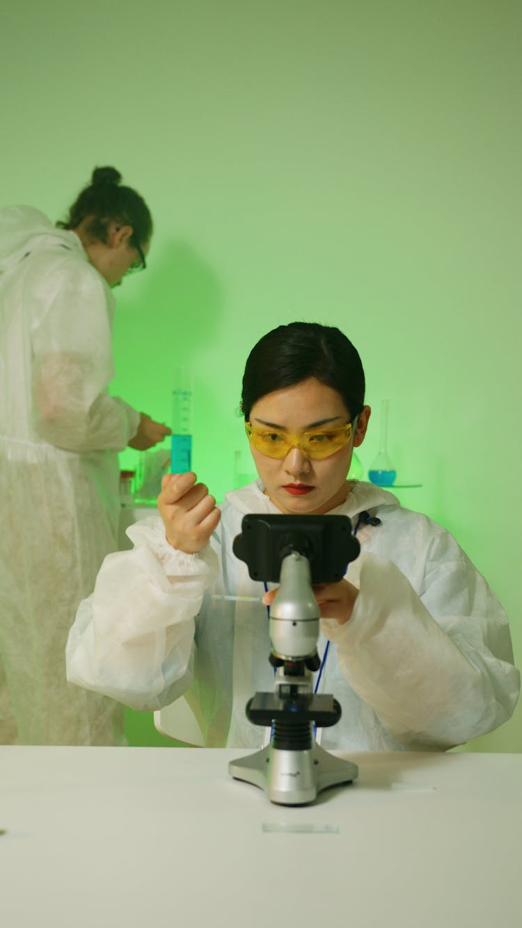 A Chemist Holding A Chemical On A Test Tube Analyzing On A Microscope