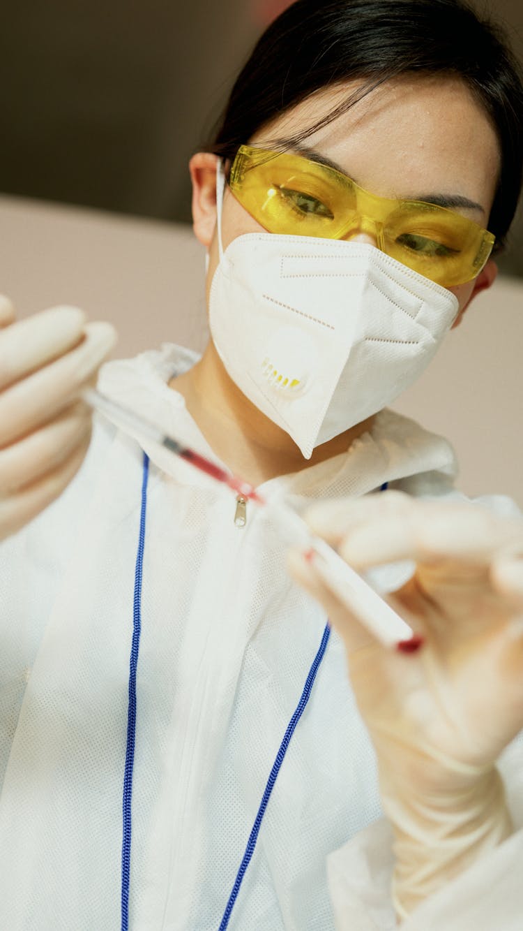 A Chemist Holding A Syringe Doing Research Work