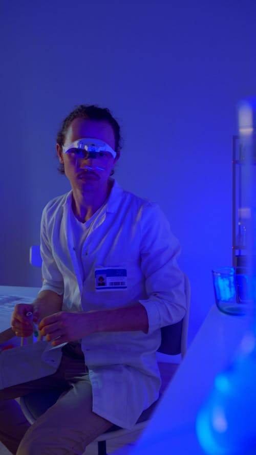 A Man Sitting in a Laboratory Wearing a Magnifying Eyewear
