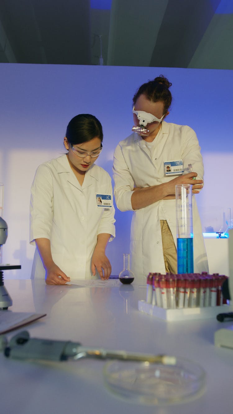 Medical Professionals Discussing On A Table Results On Paper Inside A Science Laboratory