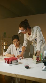 Two scientists in lab coats conducting research and analysis in a modern laboratory.