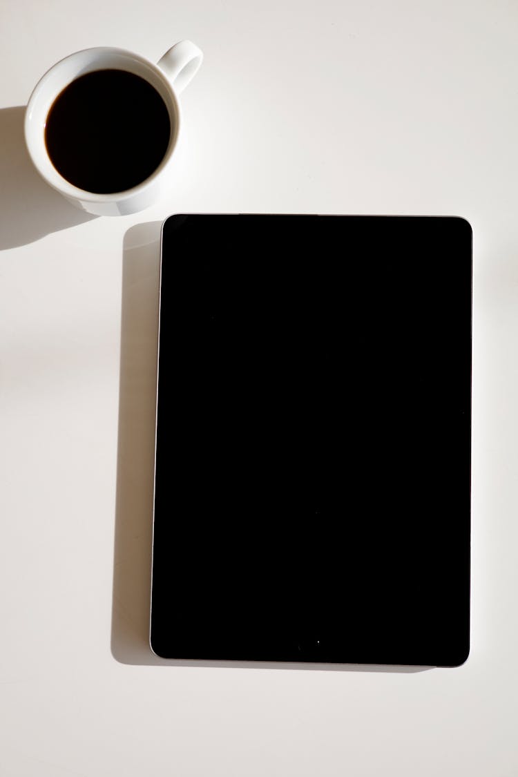 Close-Up Shot Of A Black Ipad On White Surface