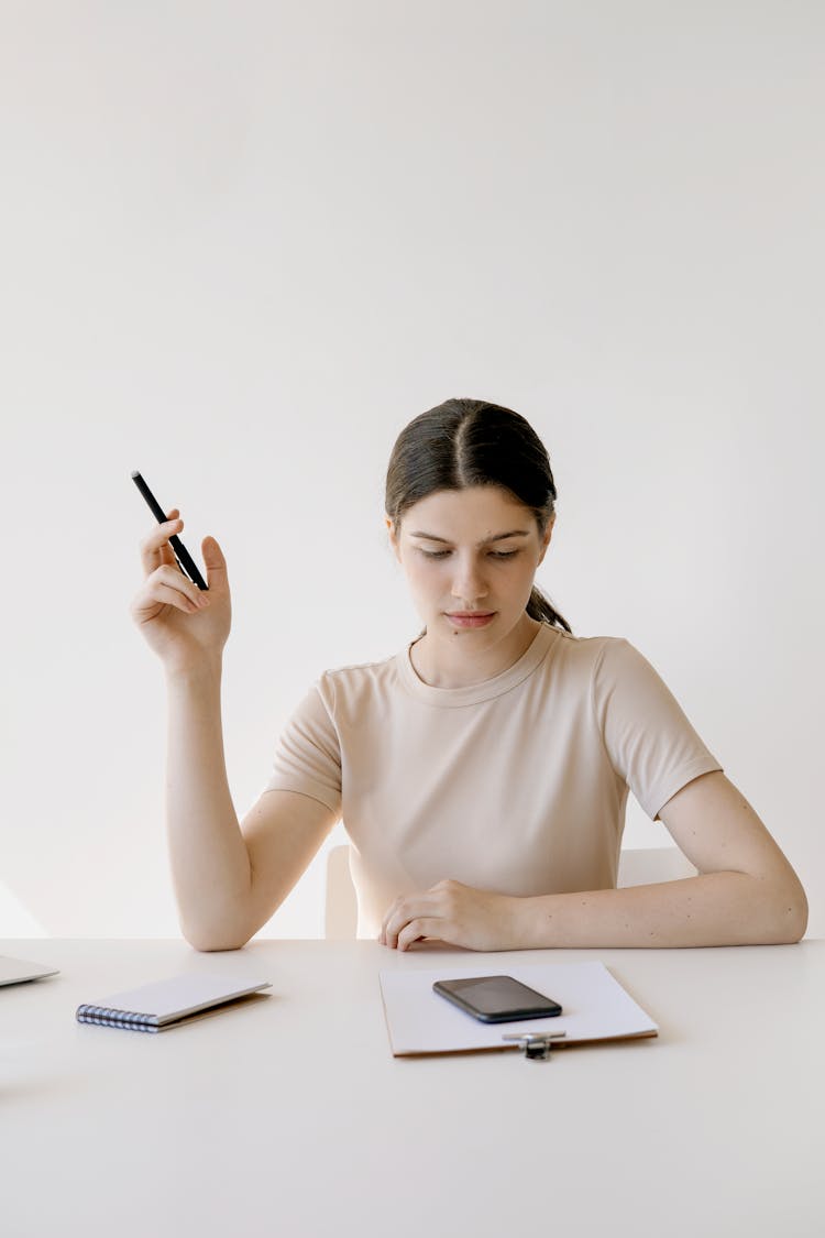 Pensive Woman Holding A Pen 