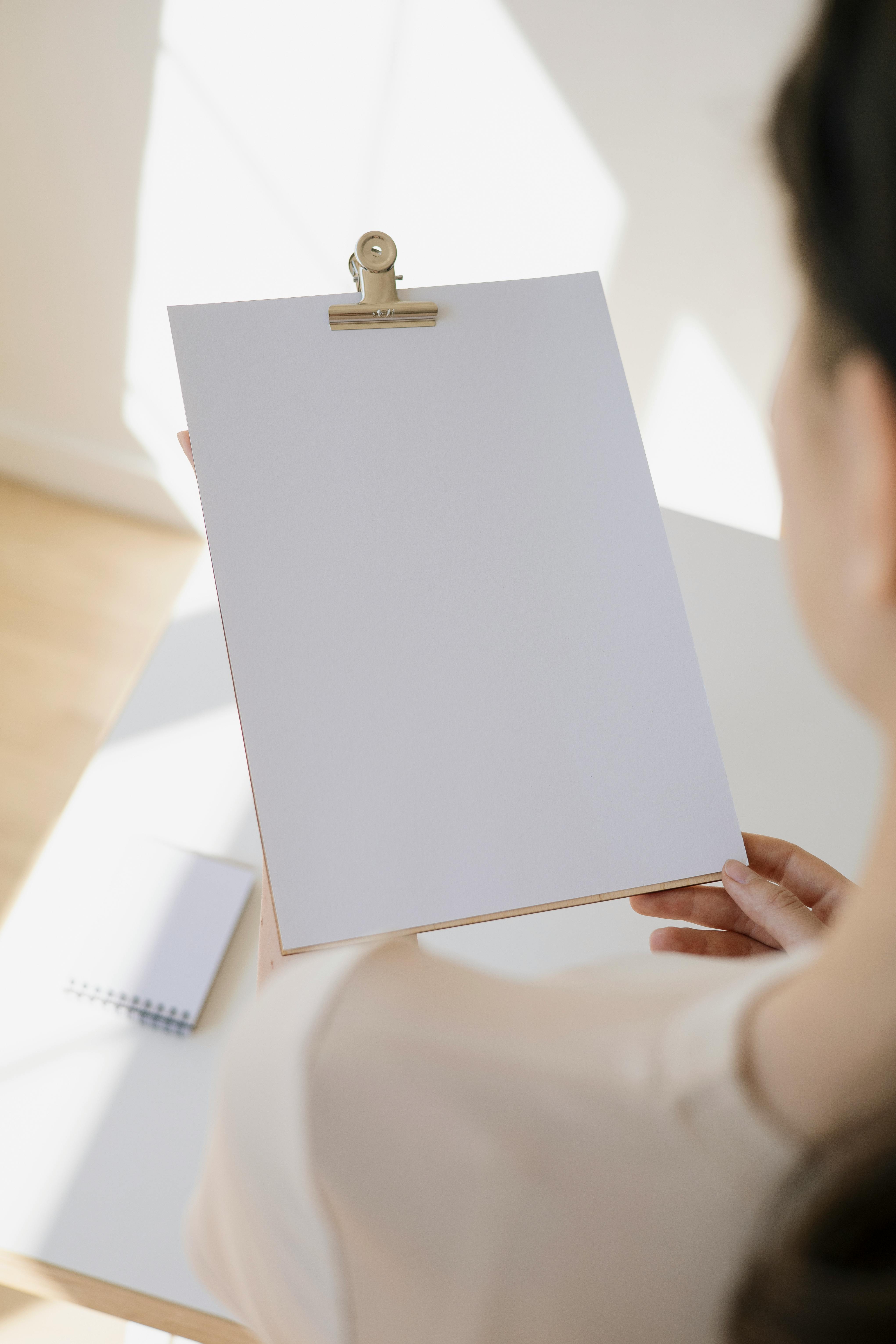 a woman holding a blank white paper