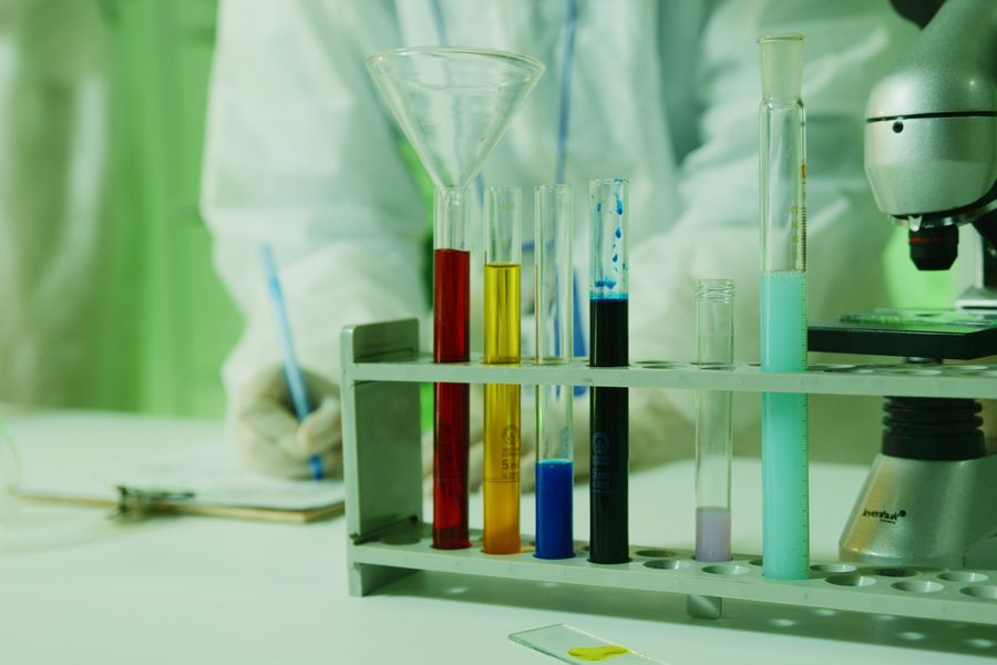 Close-up photo of lab research setup with test tubes and a microscope.