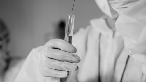 Free Scientist in protective gear working with test tube in laboratory. Stock Photo