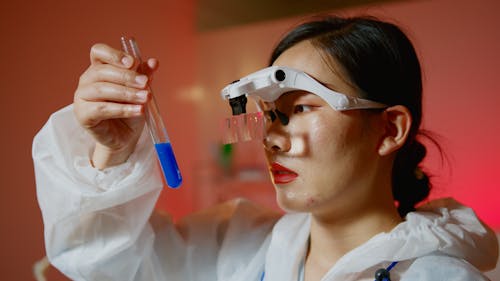 Woman Holding a Test Tube with Blue Liquid