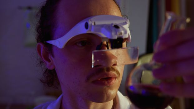 A scientist in a laboratory using advanced magnifying glasses to examine a chemical solution.