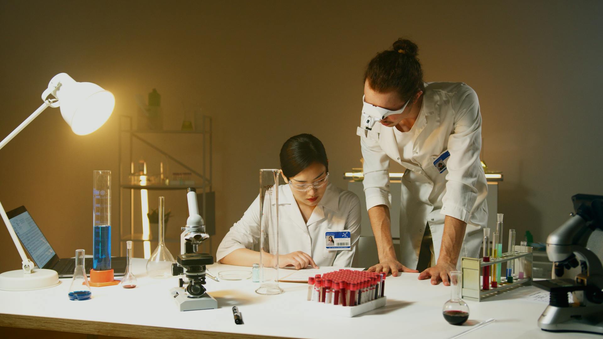 Two scientists working in a laboratory conducting experiments with various equipment and samples.