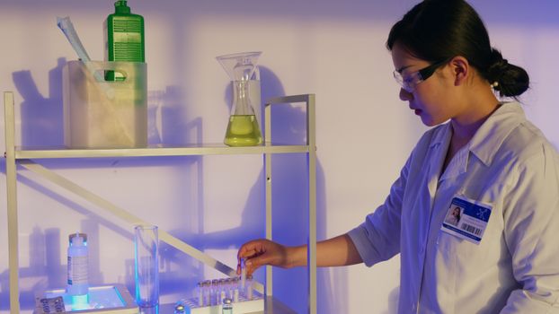 Rurki do pipet - kompletny przewodnik wyboru, użytkowania i bezpieczeństwa (2026) 3 Asian female scientist in a lab analyzing samples with various glassware.