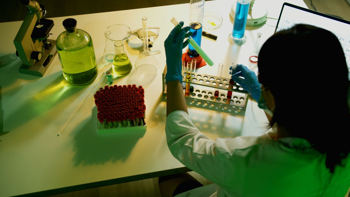 Investigadora examinando viales en un laboratorio