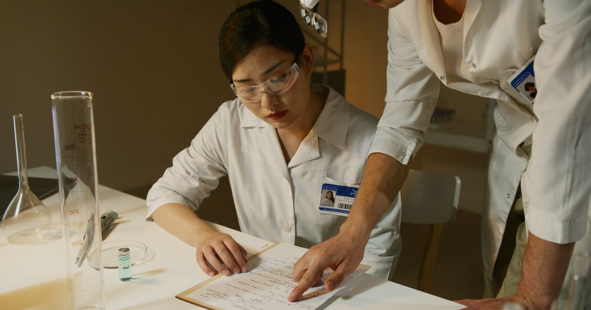 Young researcher in a UK lab reviewing fellowship application materials.