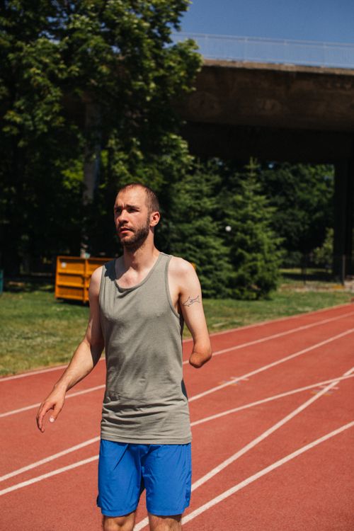 Free Amputee athlete running on a sunny day, showcasing determination and strength. Stock Photo