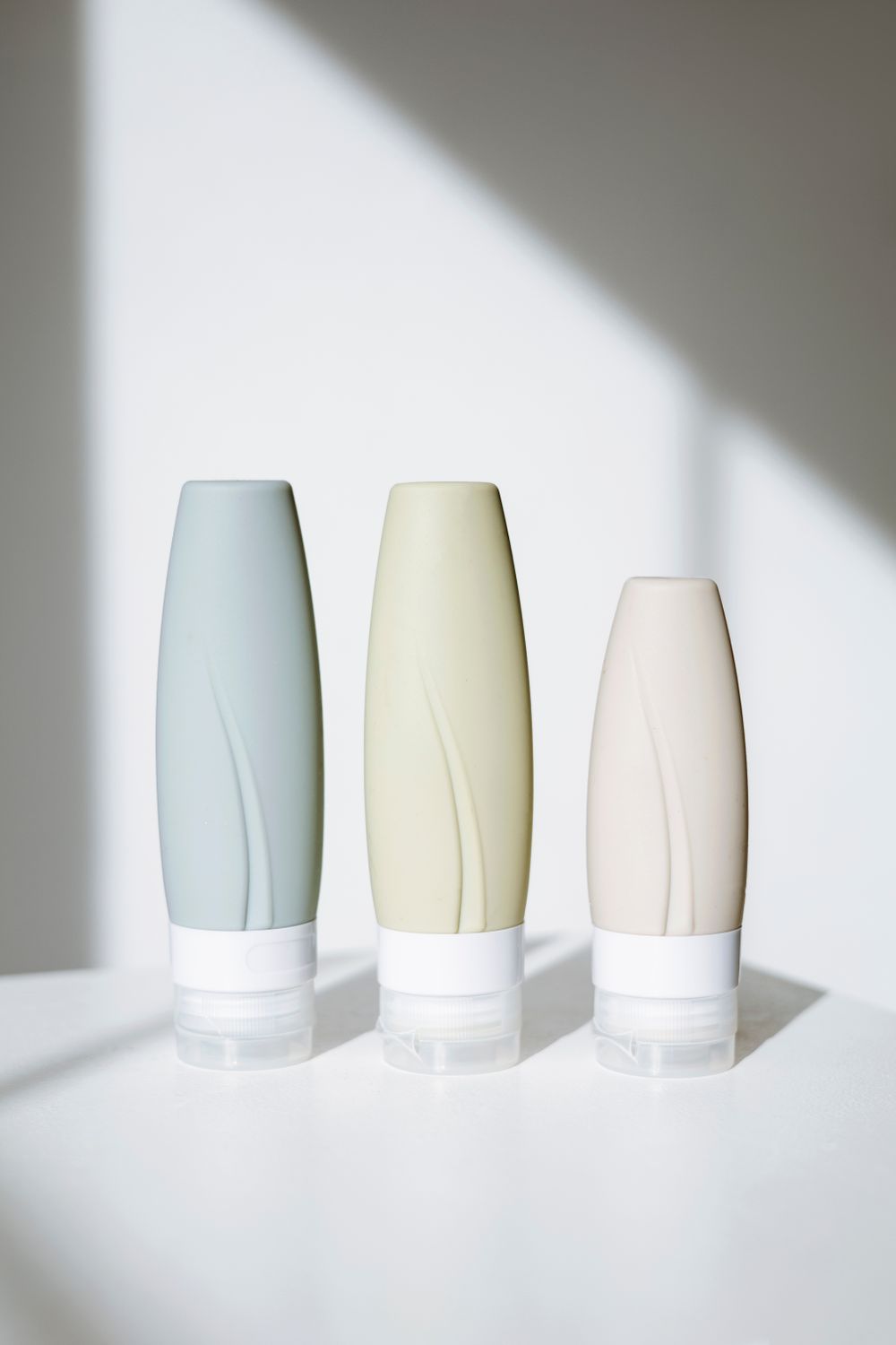 Pastel cosmetic bottles on a bright background