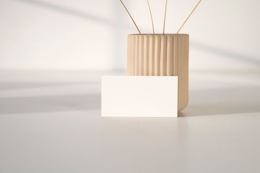 White Card leaning on a Small Container 