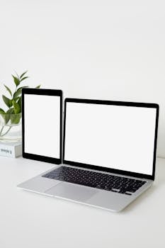 Minimalist workspace featuring a laptop and tablet with blank screens, ideal for technology demonstrations.