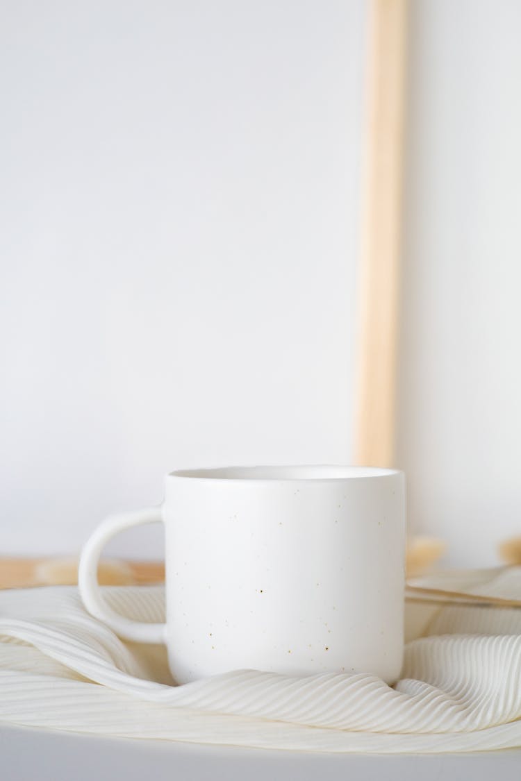 White Ceramic Mug On Table With Cloth 