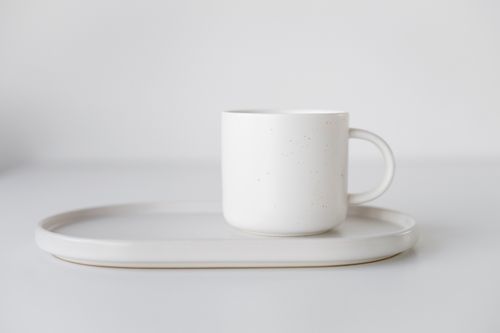Free Close-up of a white ceramic mug on a matching tray in a minimalist style. Stock Photo
