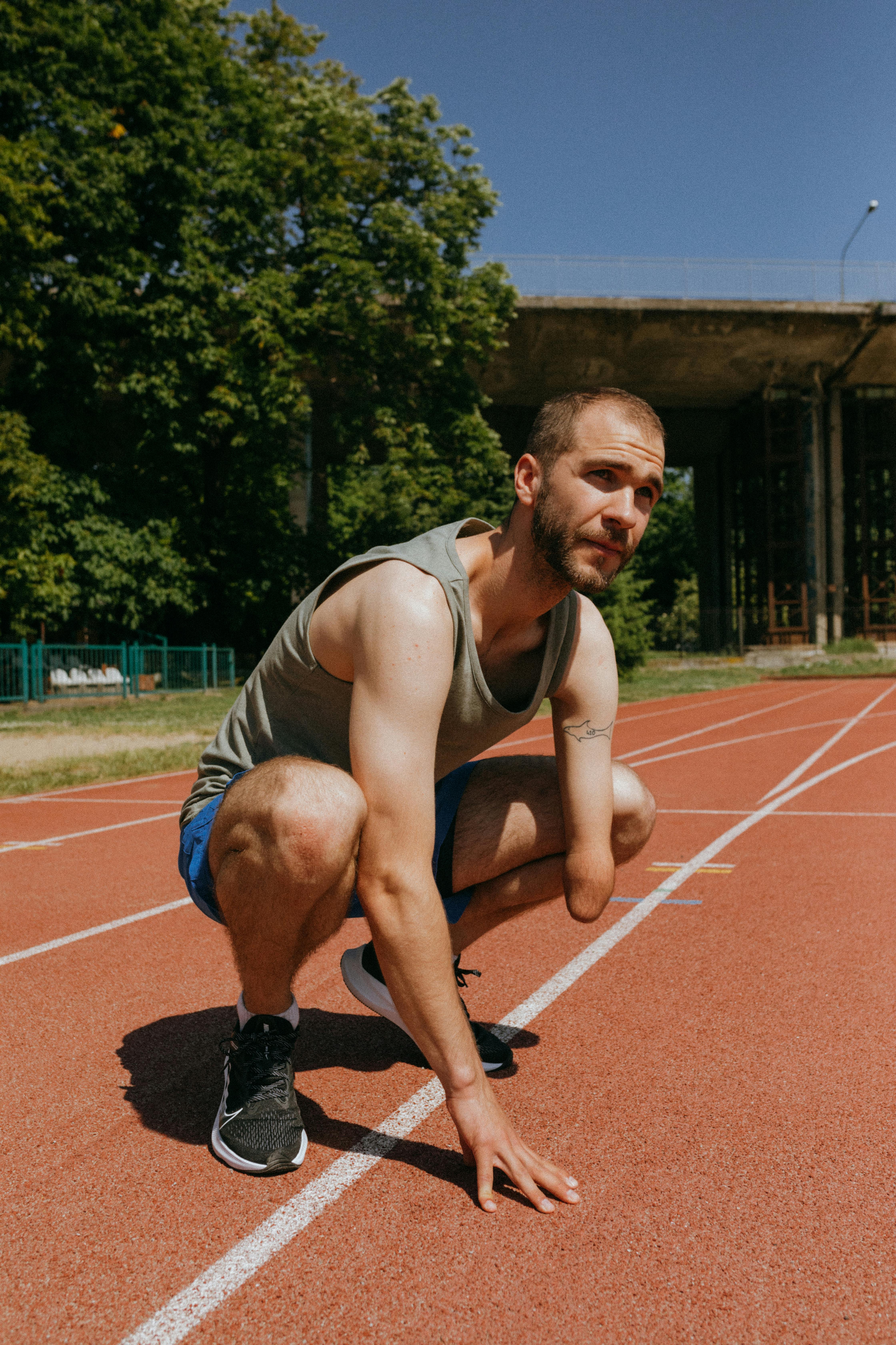 para athlete crouching on an orange running track