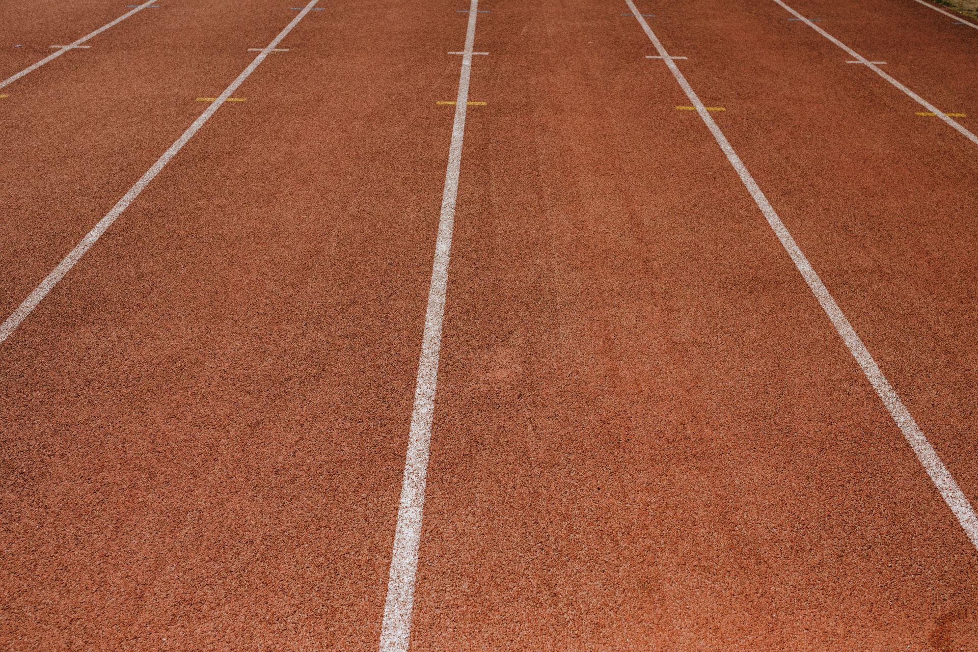 Una pista de atletismo vacía con líneas de carril bajo las luces de un estadio