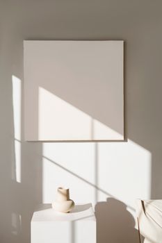 A serene minimalist art exhibit featuring an empty canvas and simple pottery.