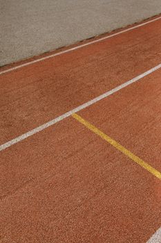 Detailed view of track lines on a running track with distinct yellow and white markings.