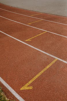 Detailed view of running track showing distinct white and yellow lines for athletics sports.