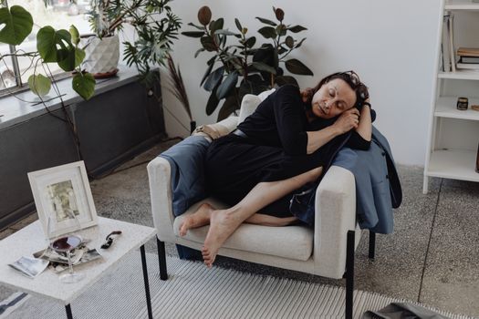 A senior woman asleep on an armchair in a cozy indoor setting