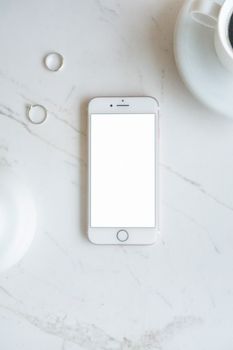 Modern smartphone mockup on marble surface with coffee. Ideal for app design presentations.