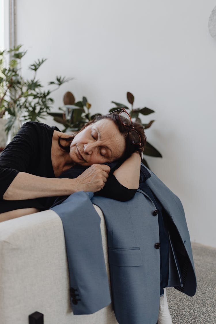 Woman In Black Top Leaning On A Blue Blazer On A Couch