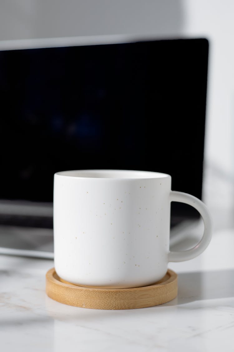 White Ceramic Mug On Brown Wooden Coaster