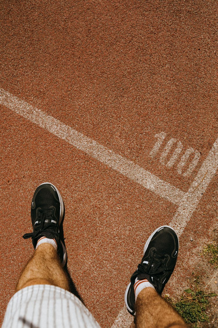 Mans Feet On The Running Sports Track 