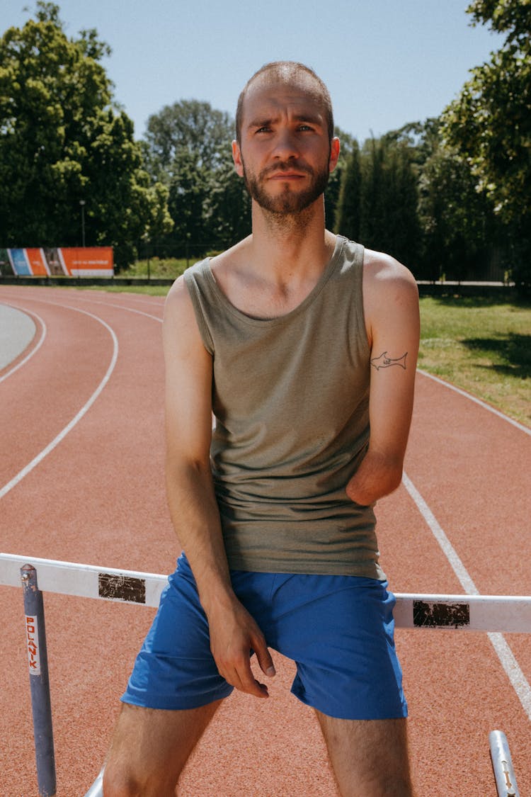 Portrait Of Man With A Missing Arm On A Running Sports Track 