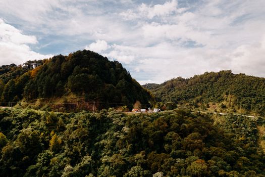 Scenic view of lush green hills in Campos do Jordão, Brazil under a cloudy sky.