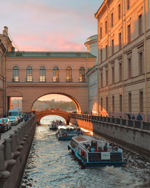 Free Charming sunset view of a canal with buildings and tour boats, capturing the essence of city life. Stock Photo