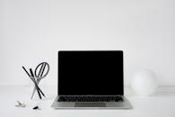 Laptop with Black Screen Beside a Pencil Holder